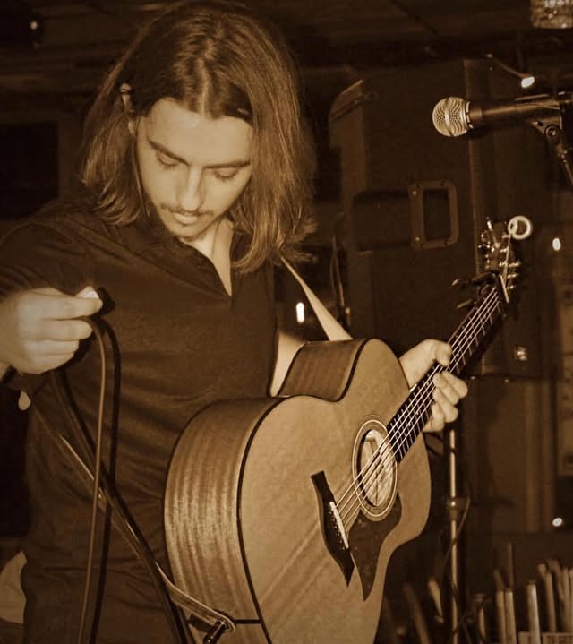 An acoustic musician performing at The Press